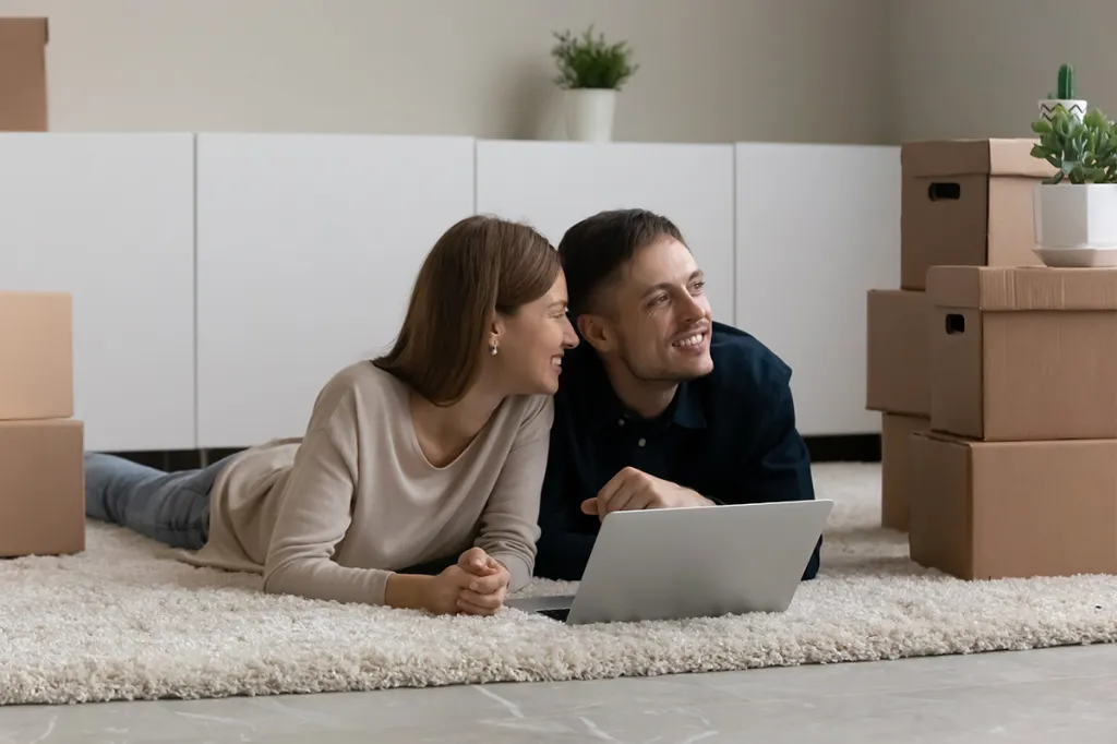 Two renters smiling on the floor, happy about their flexible rent plan